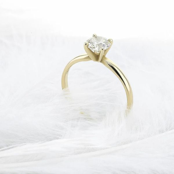 A stunning 0.5-carat round brilliant cut solitaire engagement ring in 10K yellow gold with four prongs, featuring a Solarite lab-grown diamond for women