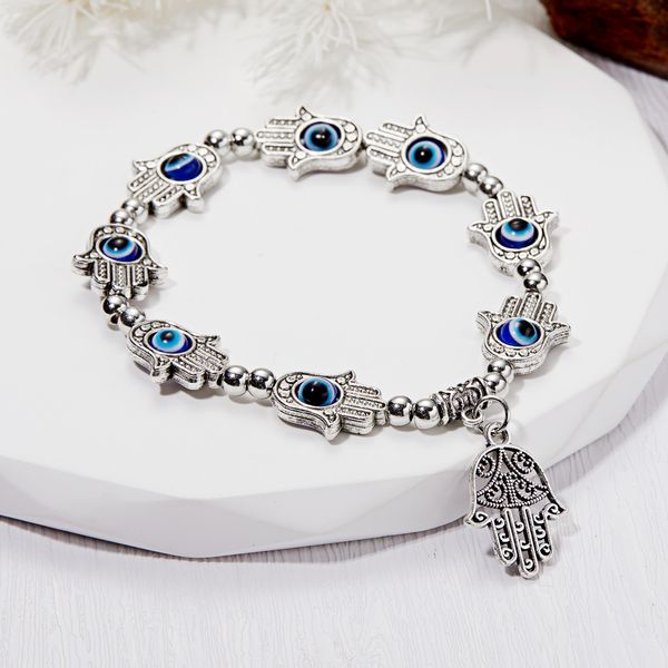 Antique silver bracelet featuring Fatima hand and evil eye charms, stretchable for easy wear