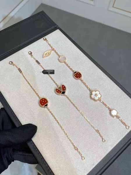 Bracelet featuring a sterling silver clover and ladybug design with 18k rose gold accents, double-sided red chalcedony stones, and durable titanium steel for luck