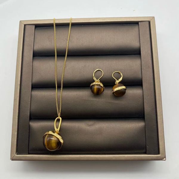 Chic 14k gold women's necklace featuring a stylish celi tiger's eye stone ball drop net design with matching cat earrings for a fashionable look