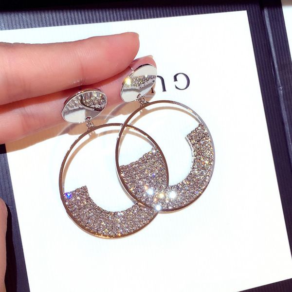 Crystal dangle earrings featuring a rotatable floral circle design in sterling silver, a unique and exaggerated needle style perfect for women's evening wear