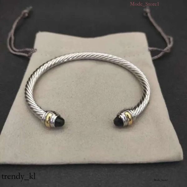 David Yurman's 2024 DY bracelet features a stylish cable design with gold, silver, and pearl accents, offering fashionable unisex jewelry in cross bangle form