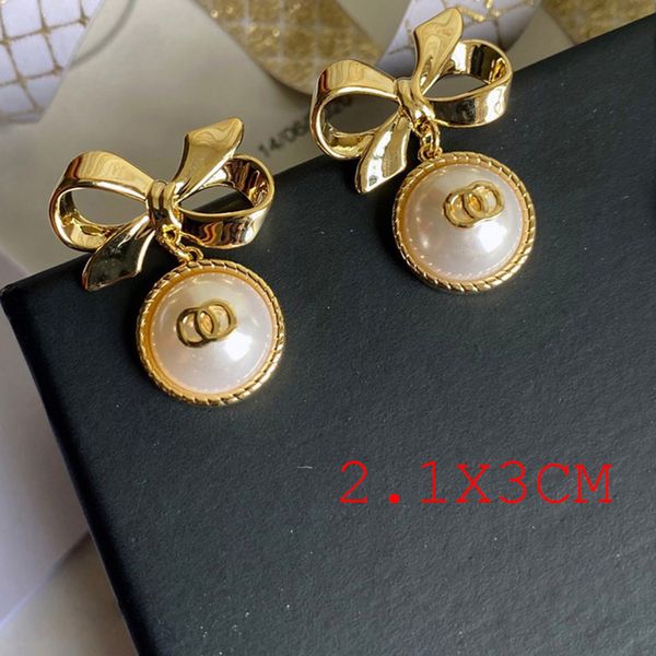 Designer crystal and pearl bowknot ear studs with gold brass stamp lettering for elegant women's fashion and weddings