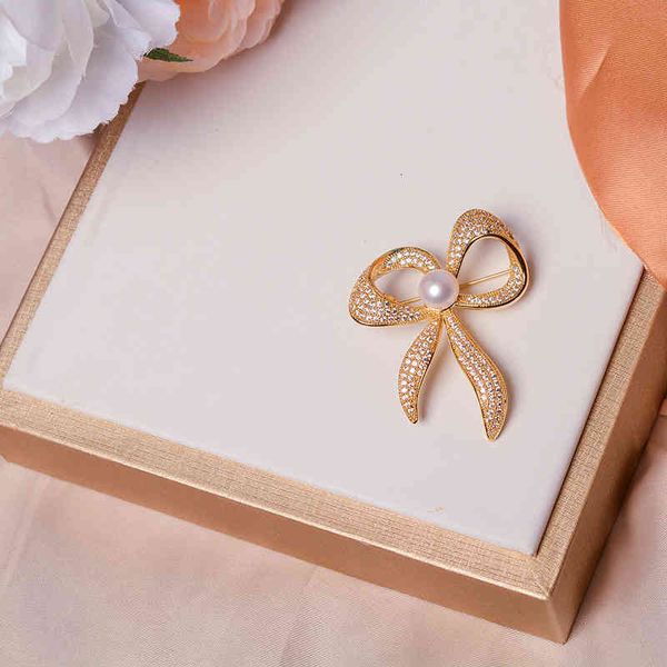Elegant brooch featuring natural pearls, inspired by ethnic designs, perfect for stylish 2021 outfits