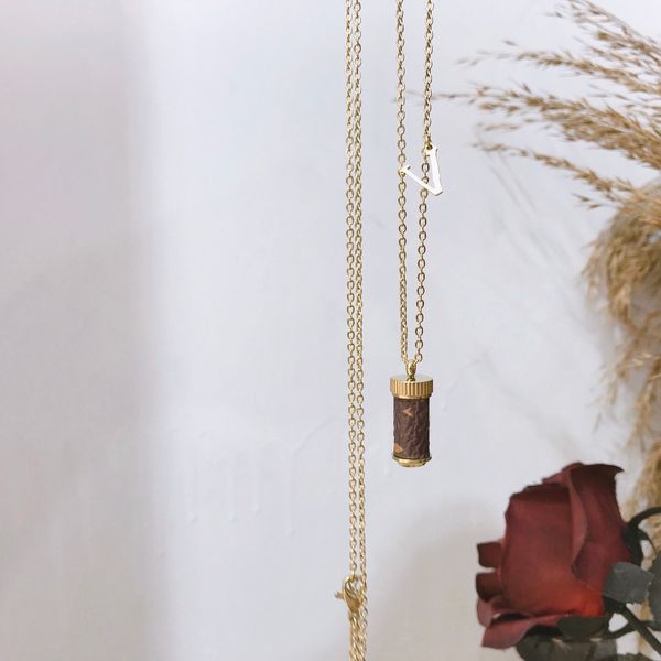Elegant designer-style pendant necklace featuring a classic perfume bottle charm, perfect for seasonal fashion