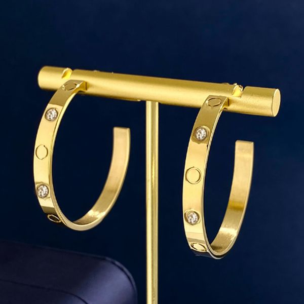 Elegant gold diamond stud earrings in titanium steel with 18K love design, stylish and simple for women, includes a bag