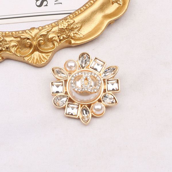 Elegant gold-tone women's brooch with chic crystal rhinestones, pearl accents, and designer detailing for weddings and parties