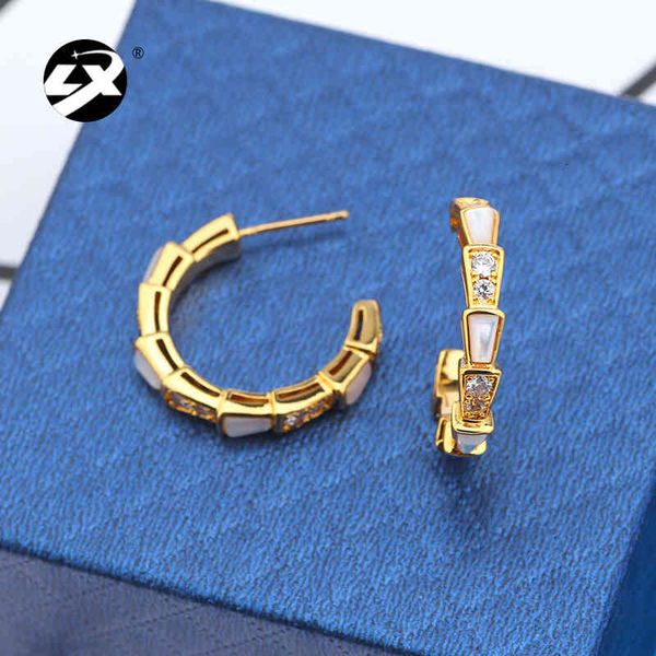 Elegant small snake bone earrings with delicate shell accents and sparkling zircon inlays on a copper base