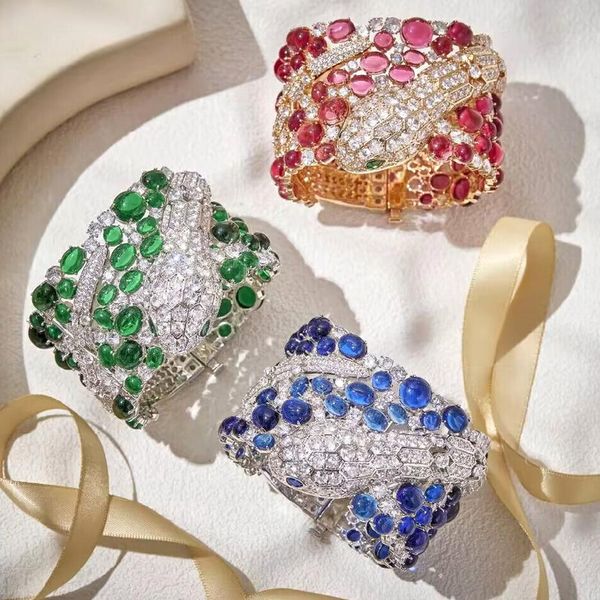 Elegant wide bangle bracelets for women featuring diamond accents and vibrant beads in red, blue, and green with gold-plated serpent design