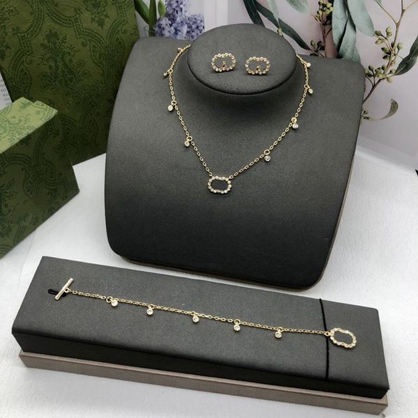 Fashionable initial pendant necklace with golden chain, diamond earrings, and pearl bracelet for women