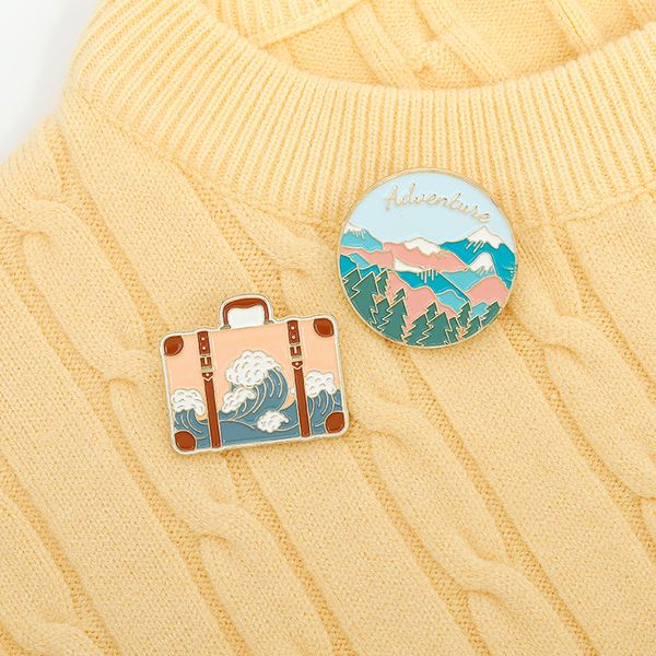 INS Women's Cartoon Round Brooches featuring natural scenery designs, gold-plated letters, travel trunk motifs, and mountain spray patterns - stylish alloy pins for student clothing accessories