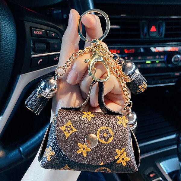 Leather keychain with brown floral plaid design, featuring tassel and mini coin purse for stylish accessory storage