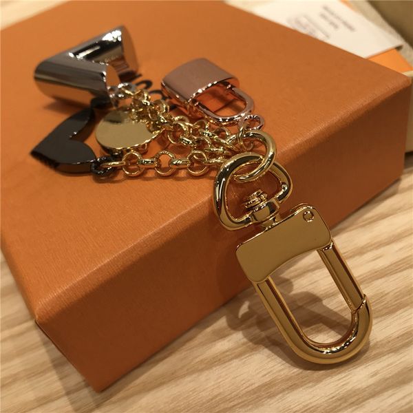 Luxurious designer gold metal keychain with classic brand letter, rose, lock, and star pendants for stylish bag accessories