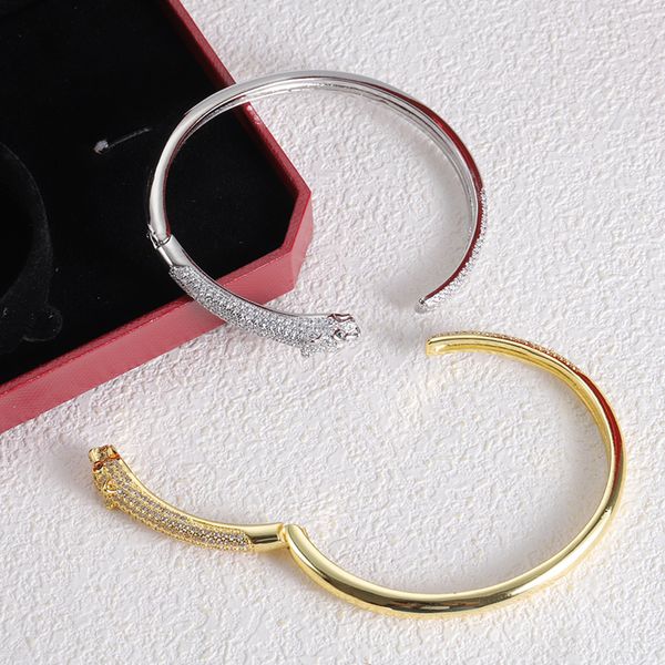 Men's designer tiger head bangle bracelet in gold and silver with diamond accents, a classic hardbody jewelry piece for women, presented in an elegant box